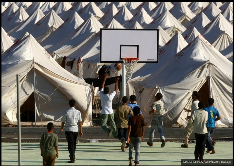 لاجئون سوريون يلعبون كرة السلة في مخيم للاجئين في بلدة Yayladagi التركية في 25 يونيو/ حزيران 2011. في 23 يونيو، اقتربت القوات السورية ودباباتهم إلى الحدود التركية، دافعة مئات الأشخاص إلى الفرار إلى تركيا.