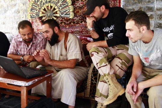 جنود الجيش السوري الحر يشاهدون مقطع فيديو على شاشة الكمبيوتر المحمول. (حامد الخطيب / رويترز)